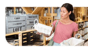 A shopper holds up a small basket while shopping at a specialty goods retail store.