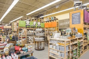 In a specialty retail store, various housewares are displayed on shelves.