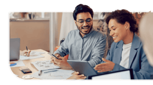 Two developers plan out a custom engineering project on a laptop