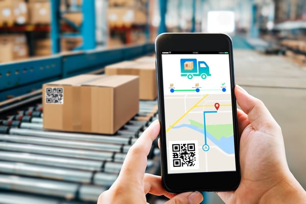 A shopper holds up their phone displaying where their package is on a map.