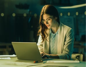 Business analyst typing on a computer reviewing a centralized inventory control center.