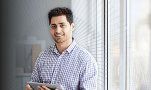 An eCommerce and retail merchant holds a tablet.