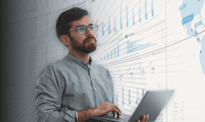A supply chain analyst looks at data on a computer.