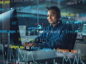 A developer types code on his desktop as he works on system integration.